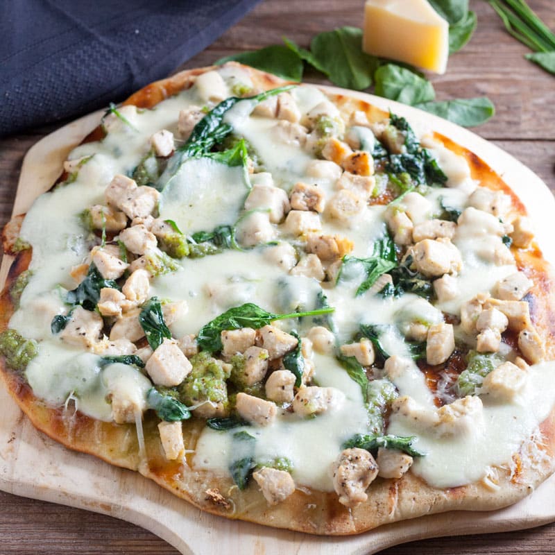 chicken florentine pizza on wooden pizza peel