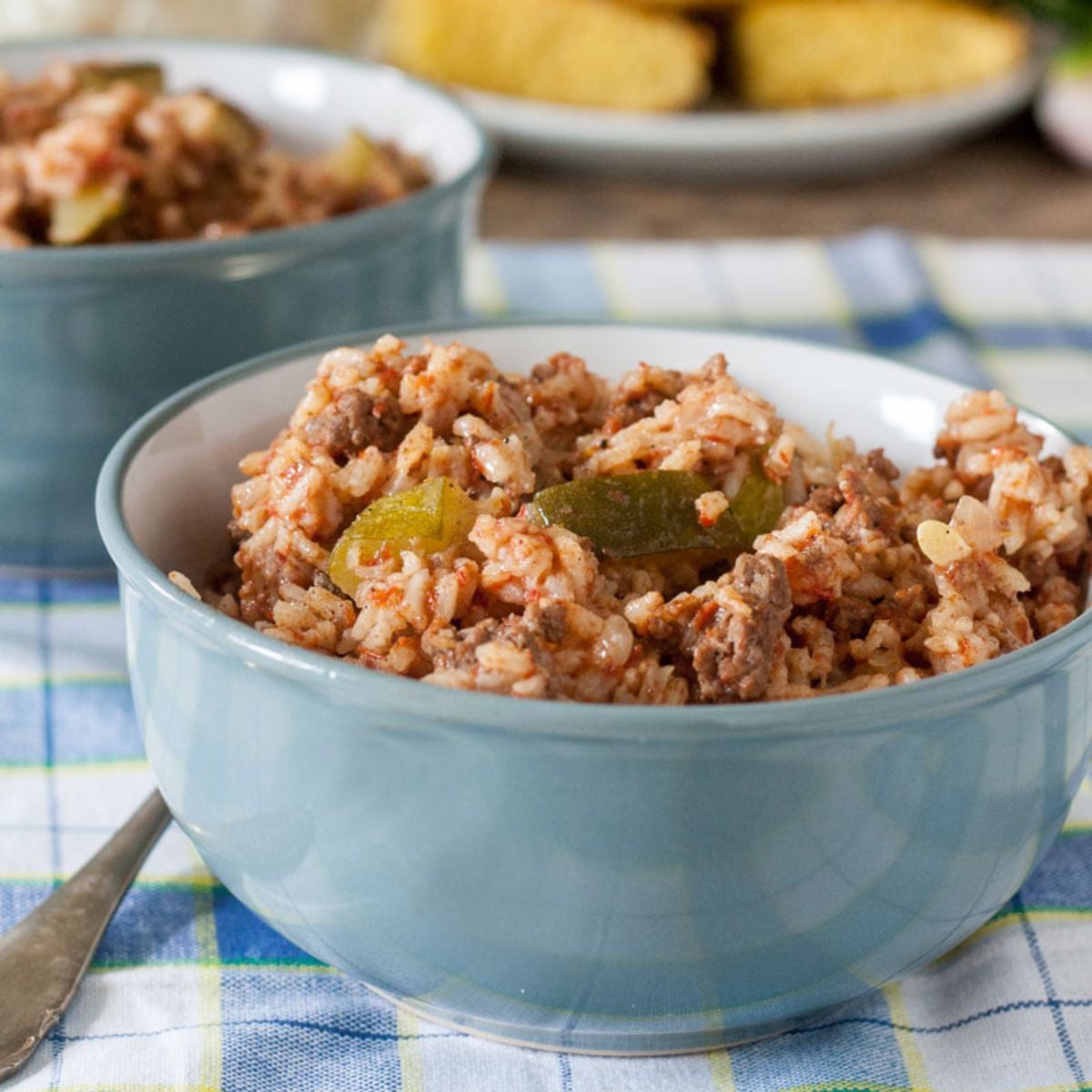 Spanish rice with ground beef and zucchini in a blue bowl.