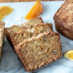 Orange pineapple quick bread sliced on marble board.