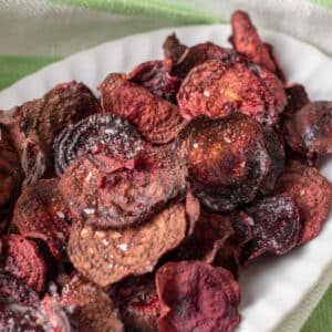 Colorful beet chips on white plate.