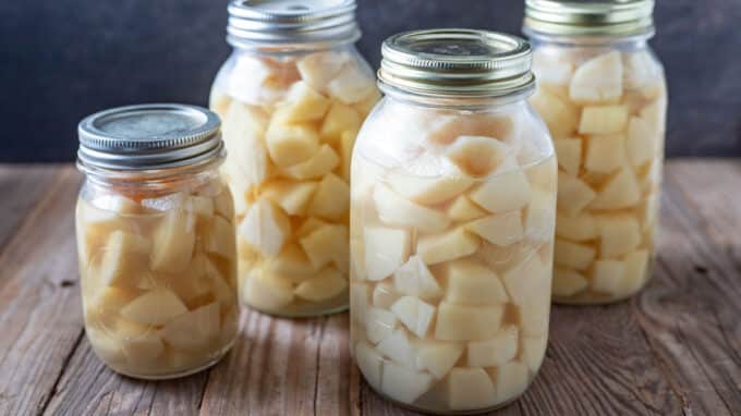 Quart and pint jars of canned diced potatoes.