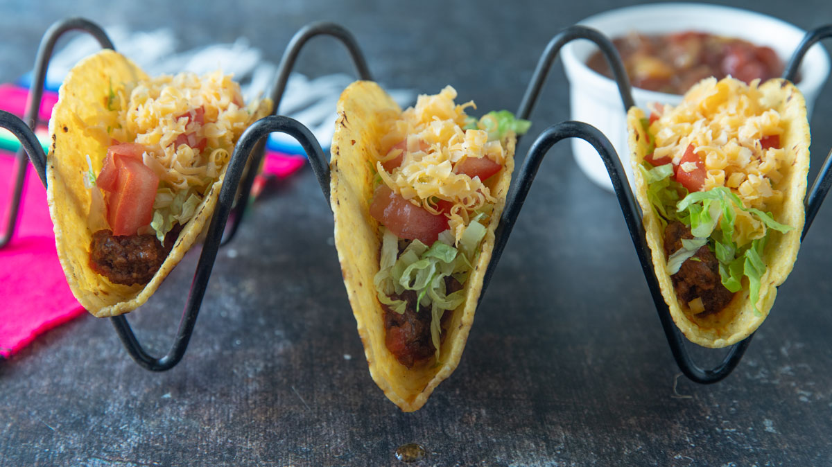 Lots of ground beef taco mix on hard shell tortillas.