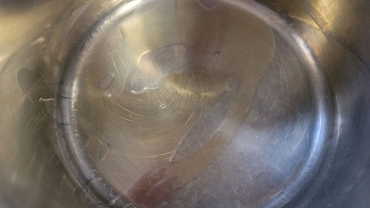 Oil added to a stainless steel Dutch oven.