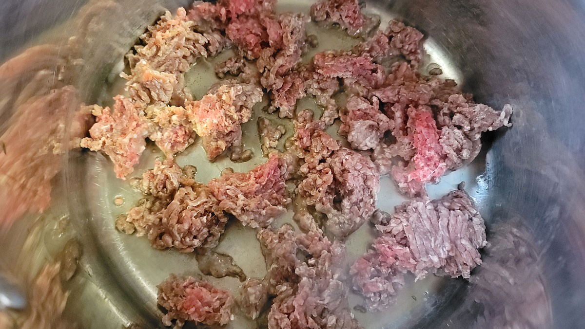 Ground beef added to the Dutch oven.