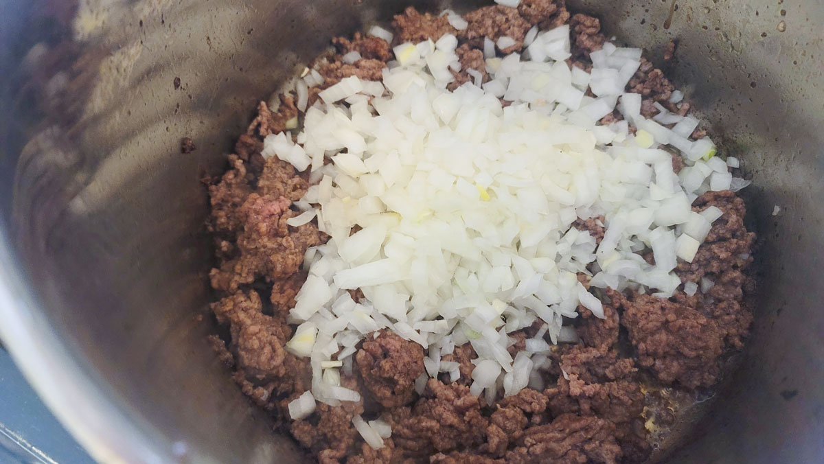 Onion added to the beef in the pan.