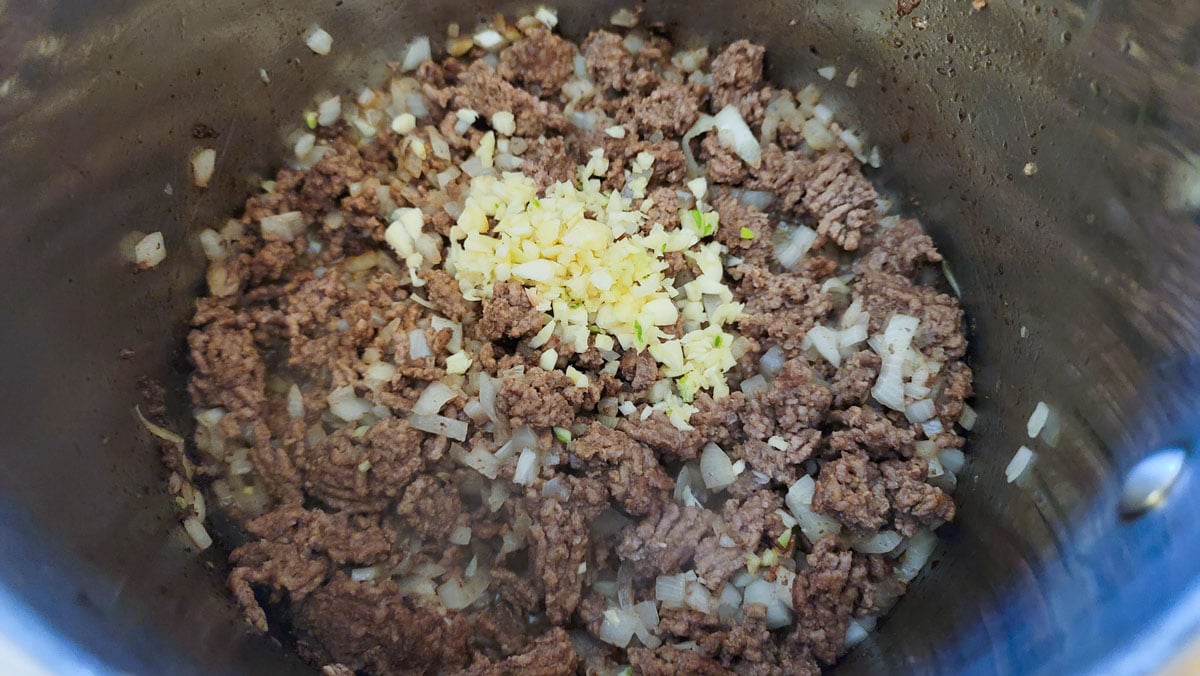 Garlic added to the meat in the pot.