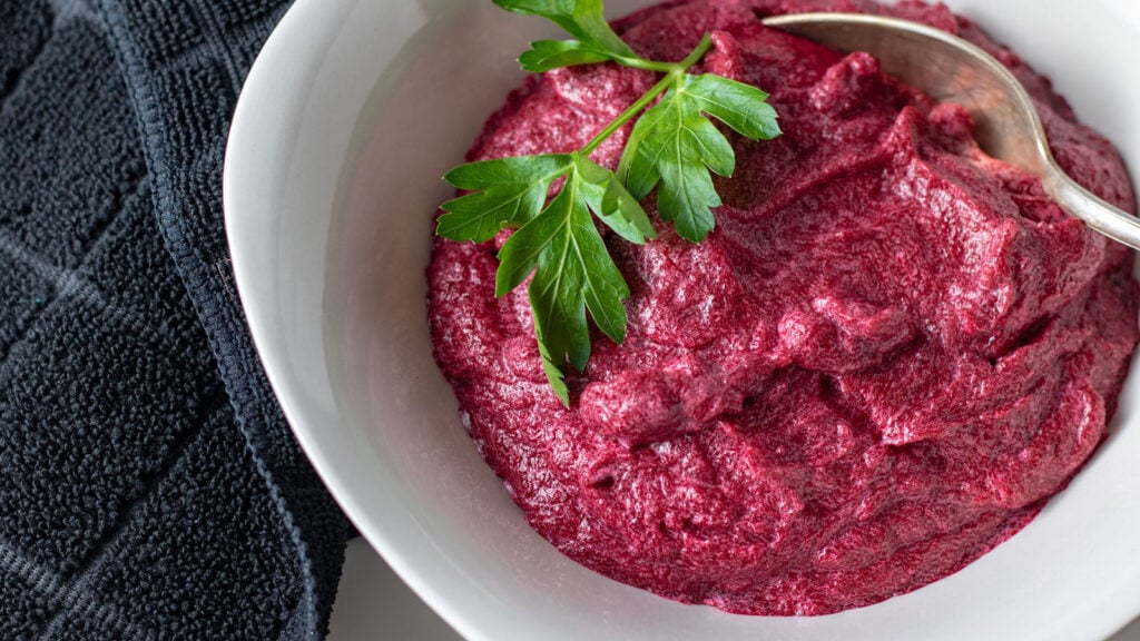 Puree in white bowl with parsley garnish.