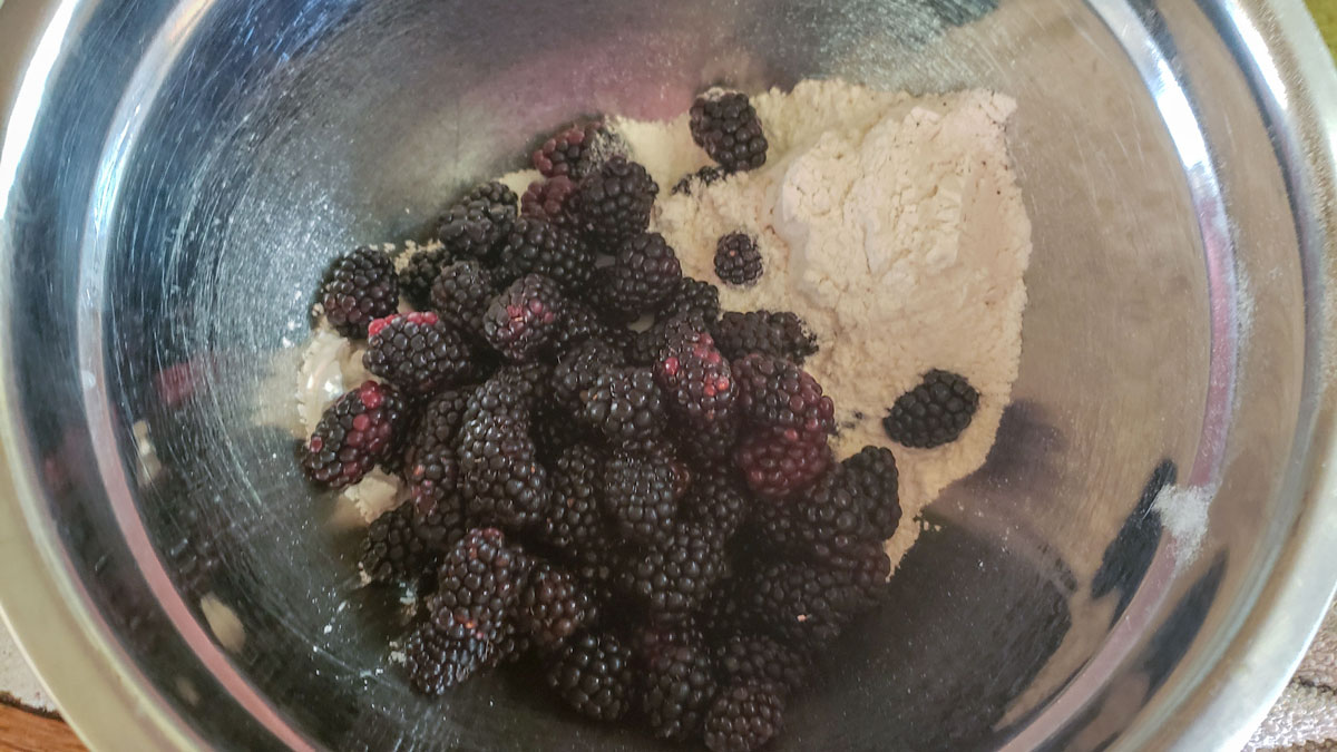 Blackberries in a bowl with dry ingredients.