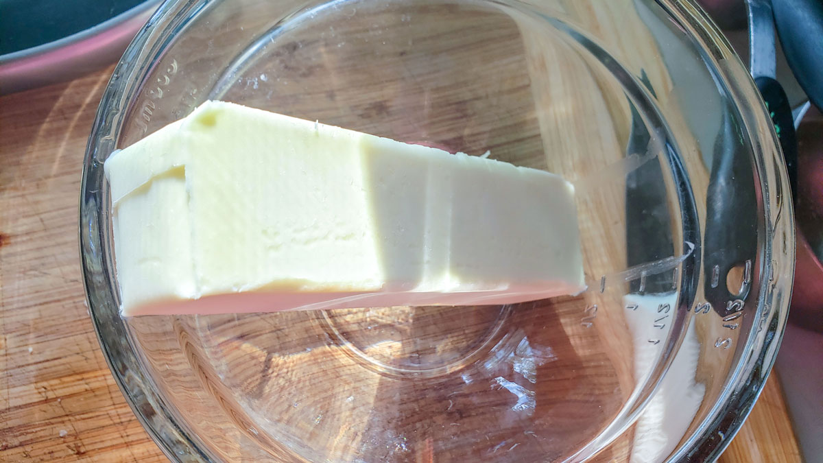 Stick of butter in a glass bowl.