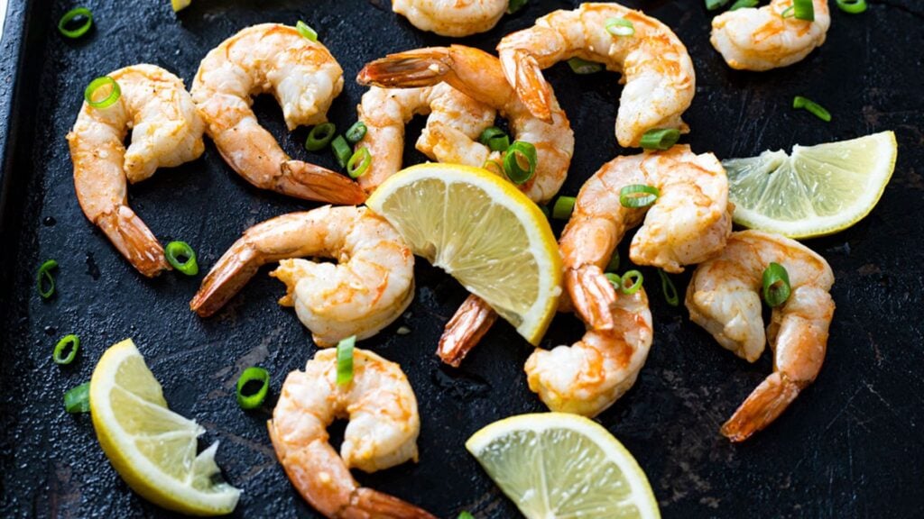 Juicy shrimp on black serving tray