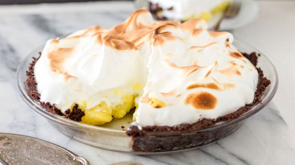 gluten free lemon meringue pie with a piece taken out to show filling