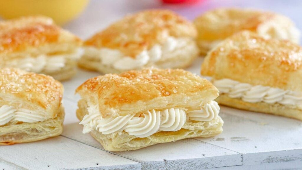 Cream filled pastries on a white board.