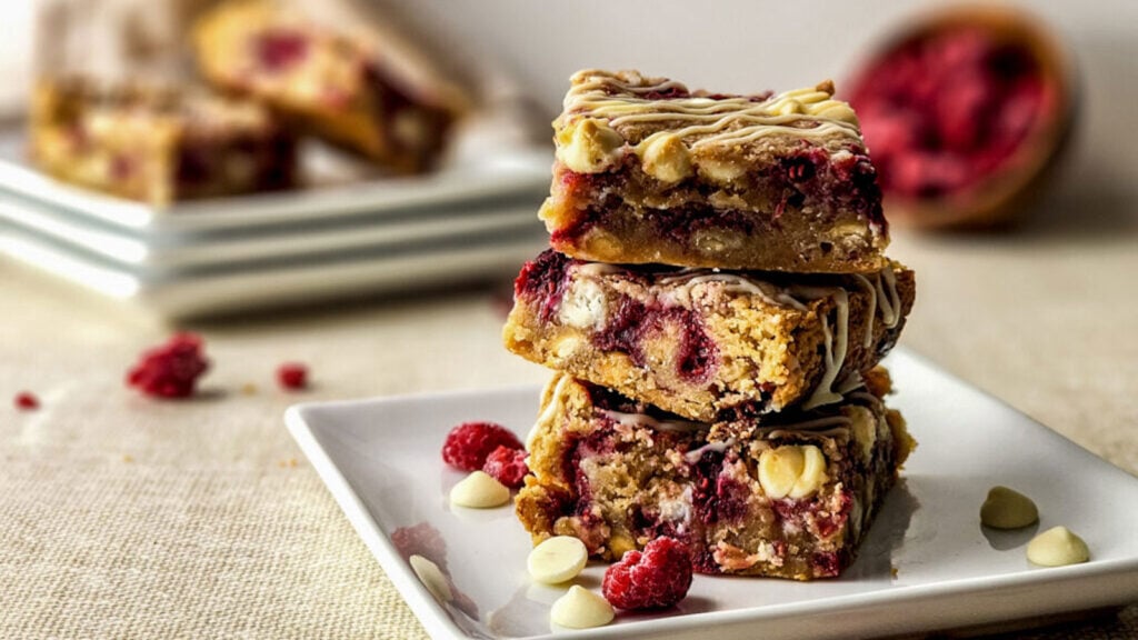 Stack of blondies with chocolate chunks and raspberries.
