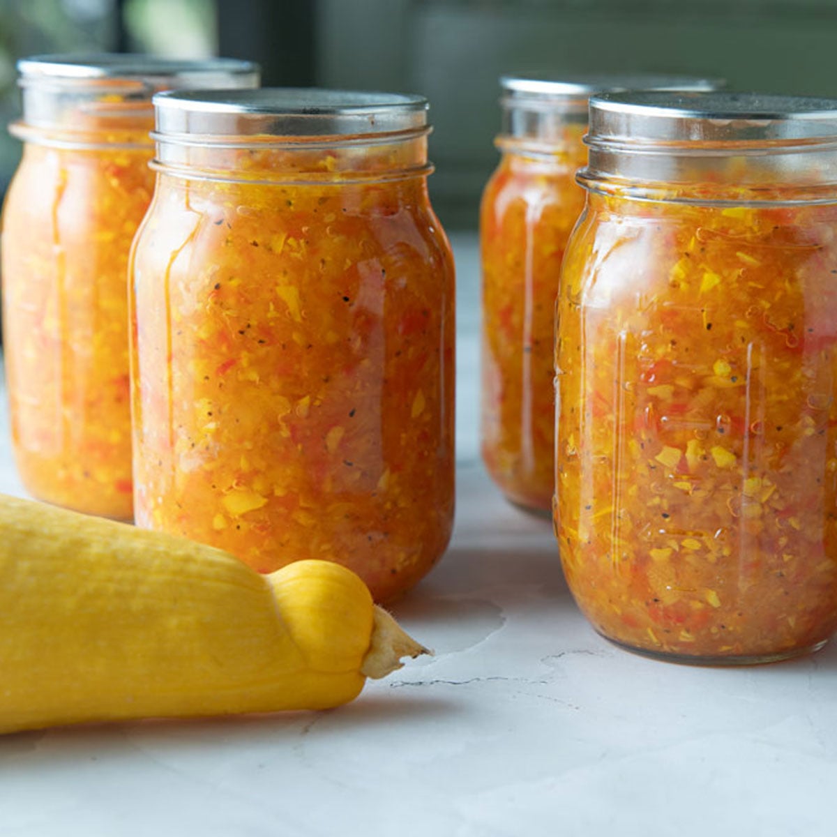 Jars of relish on a green board.