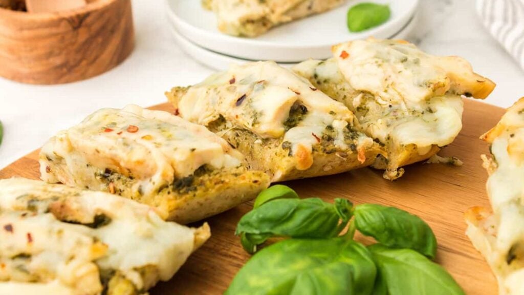 Flatbread chicken pizza on a wooden board.