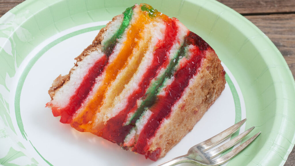 Slice of colorful rainbow jello cake.