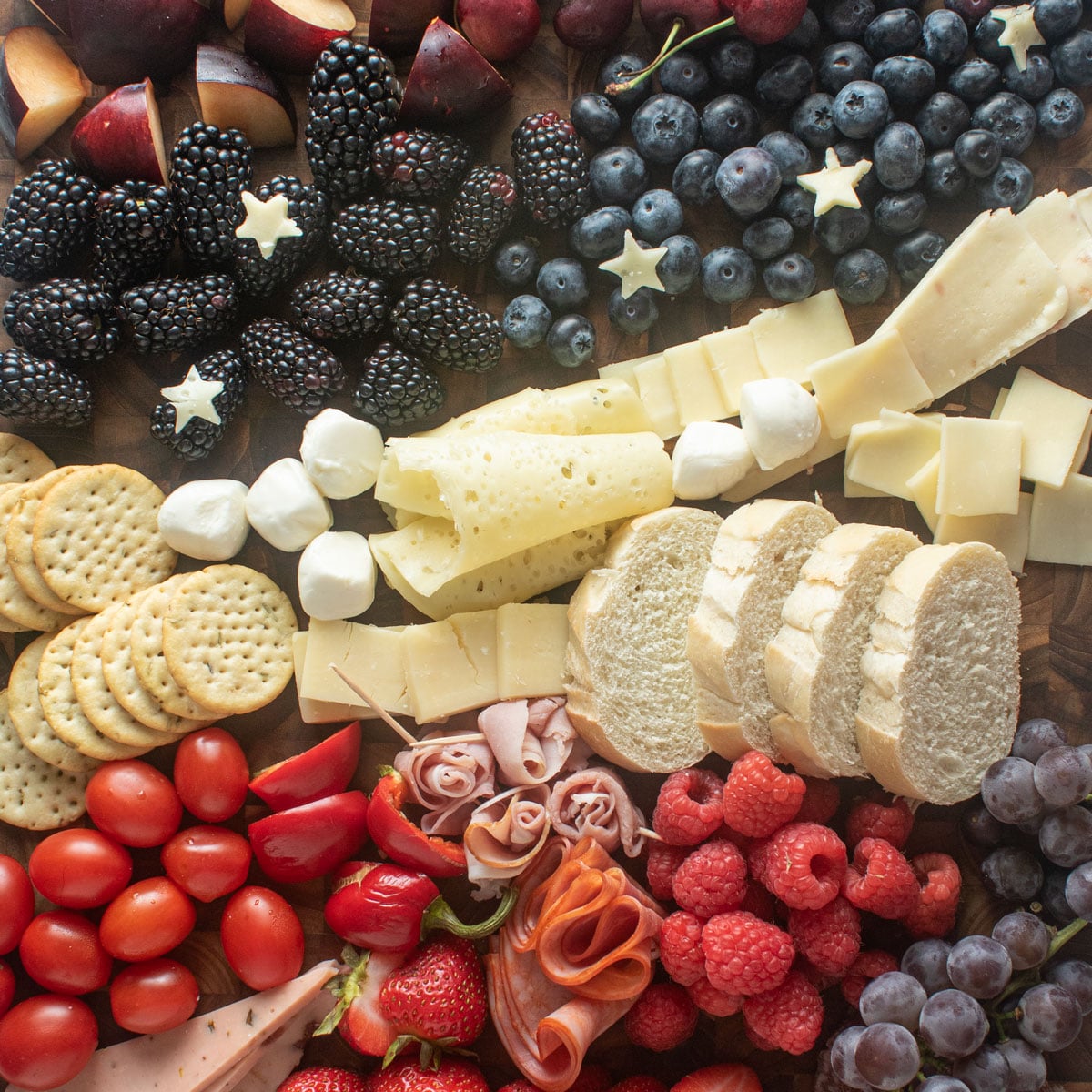 Red, white and blue grazing board with fruits and cheeses.