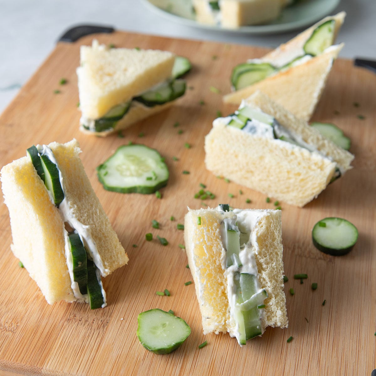Cucumber sandwiches on a wooden board.