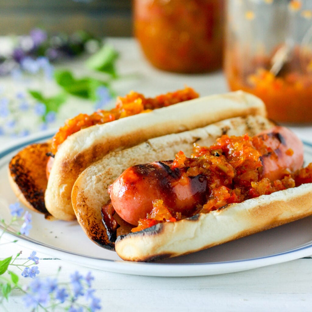 Hot pepper relish on hotdogs in buns.