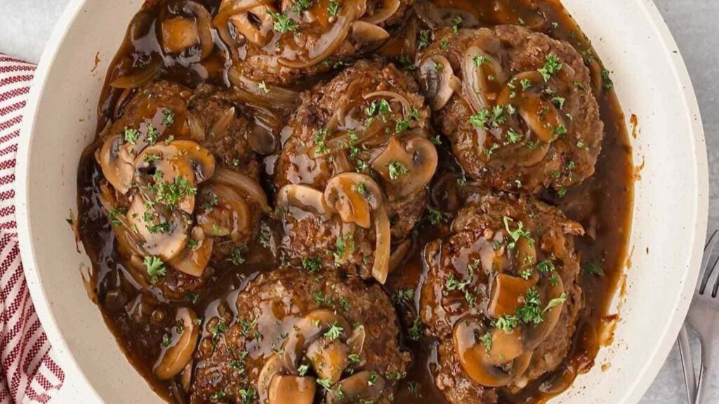 Salisbury steak in a pan.