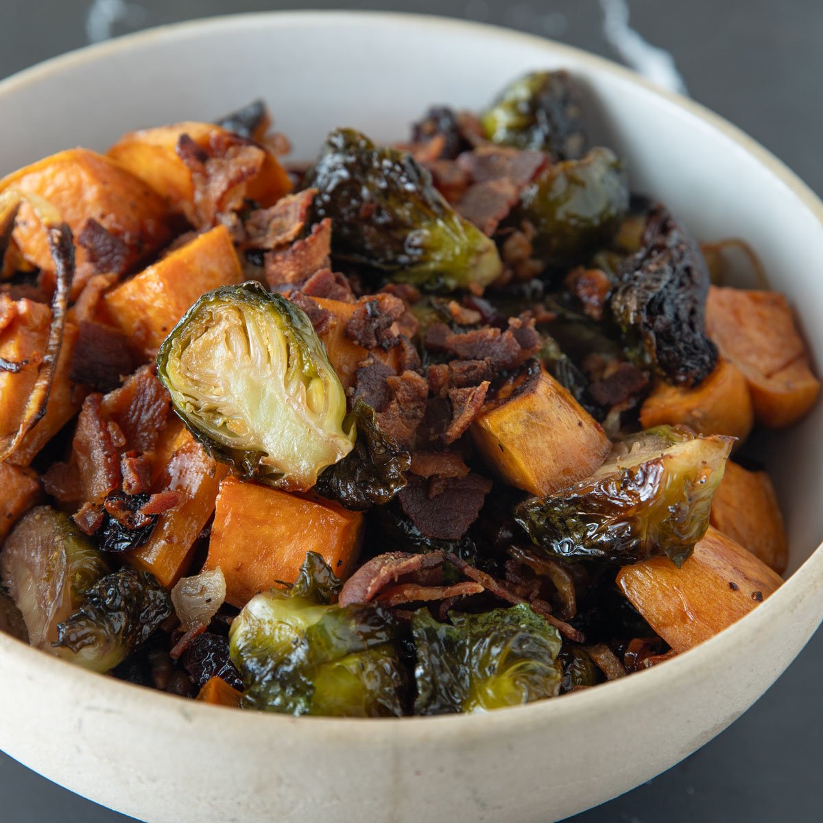 Roasted Brussels Sprouts and Sweet Potatoes in a beige bowl.