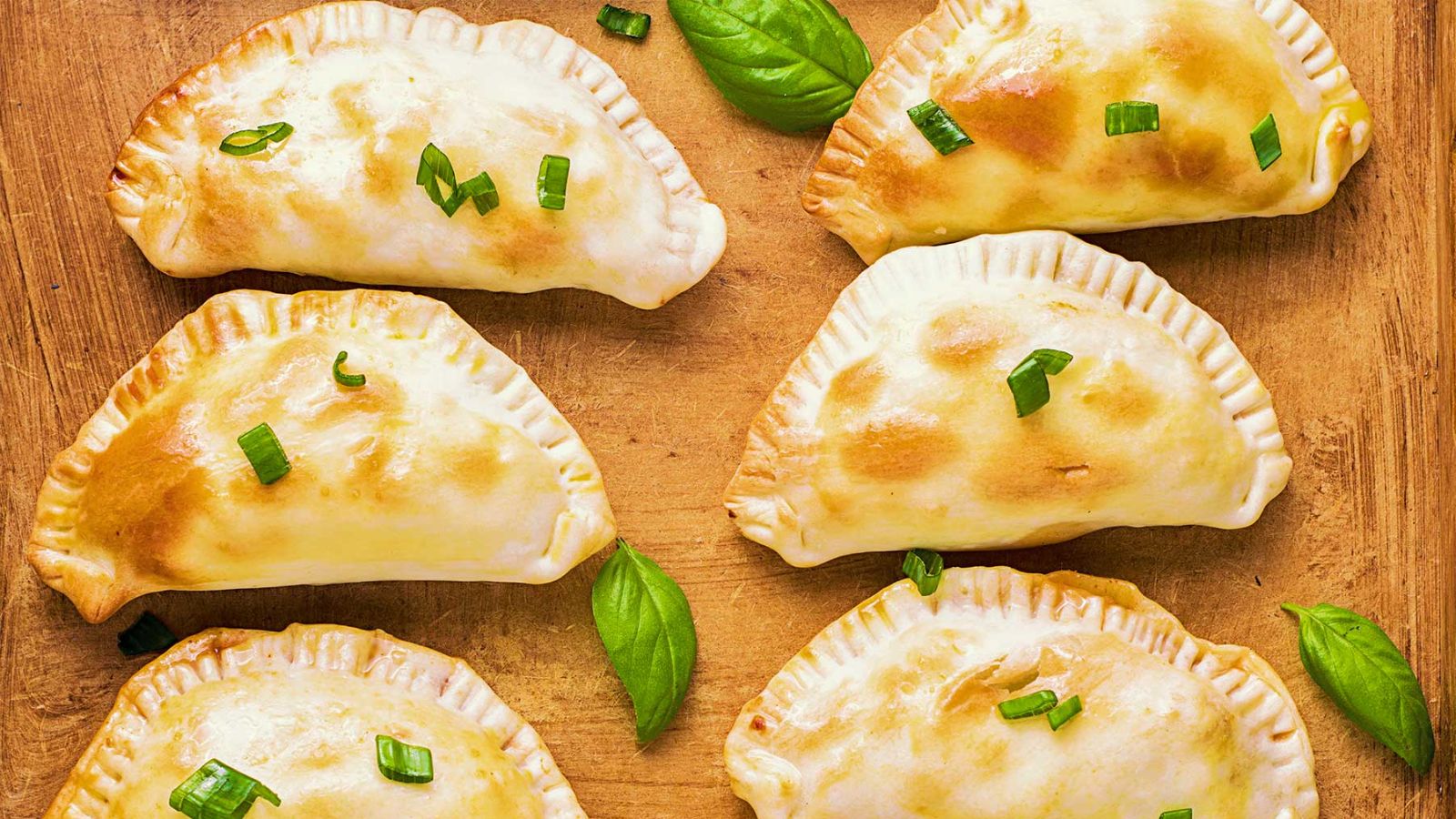 Beef empanadas on a wooden board.