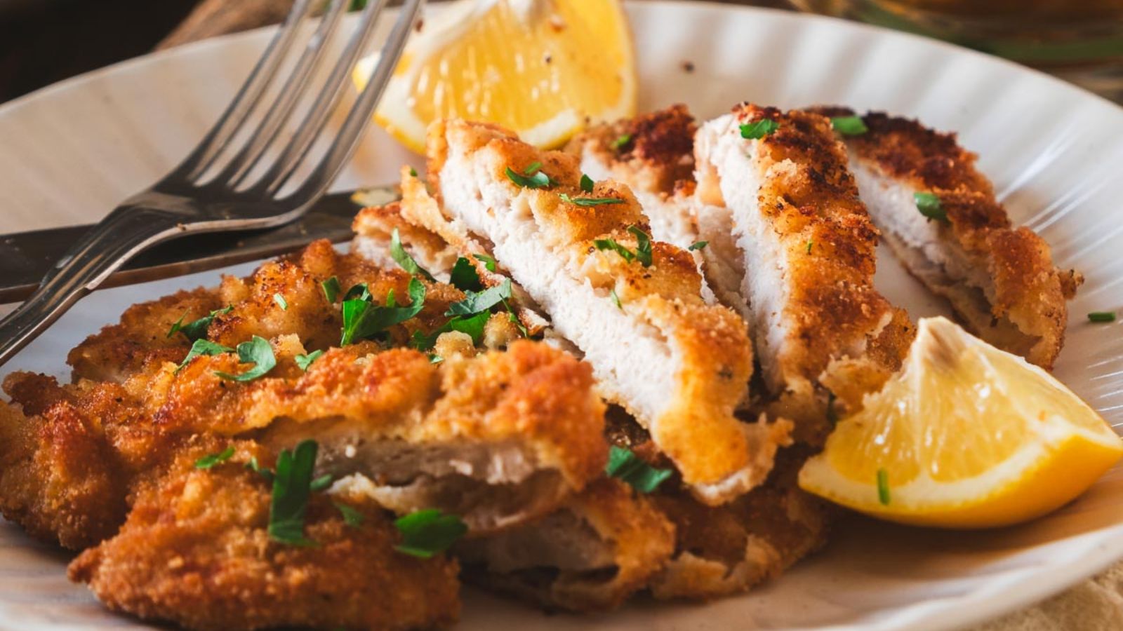 Sliced breaded pork with sliced lemon.