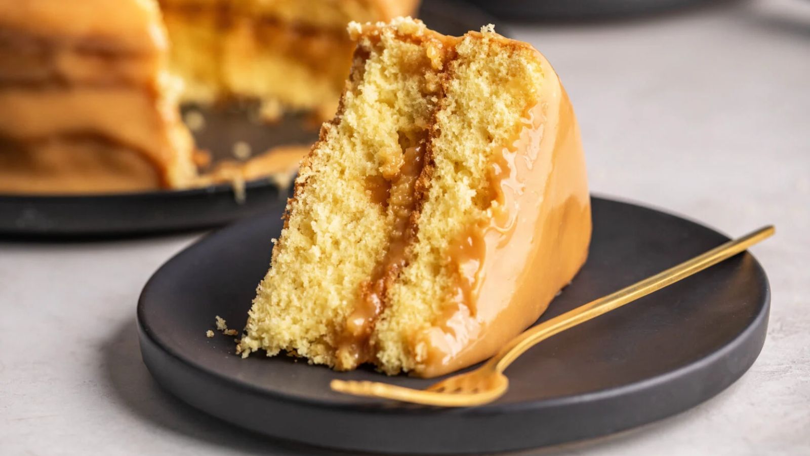 A slice of caramel cake on a plate.
