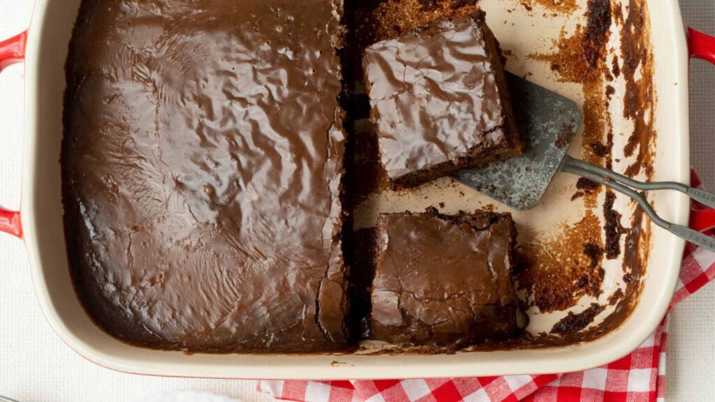 Chocolate cake with slices on a tray.