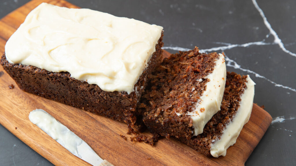 Sliced carrot cake bread with cream cheese frosting.