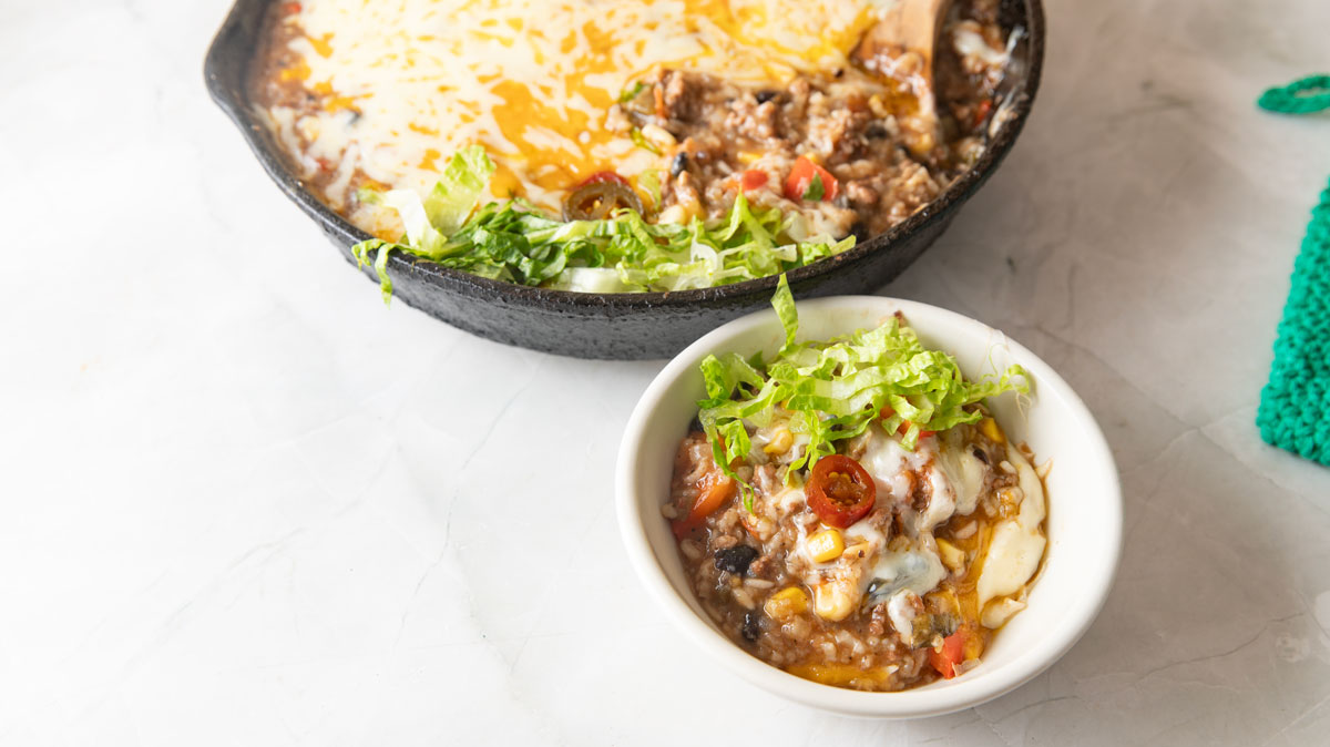 Bowl of Mexican beef and rice with cheese.