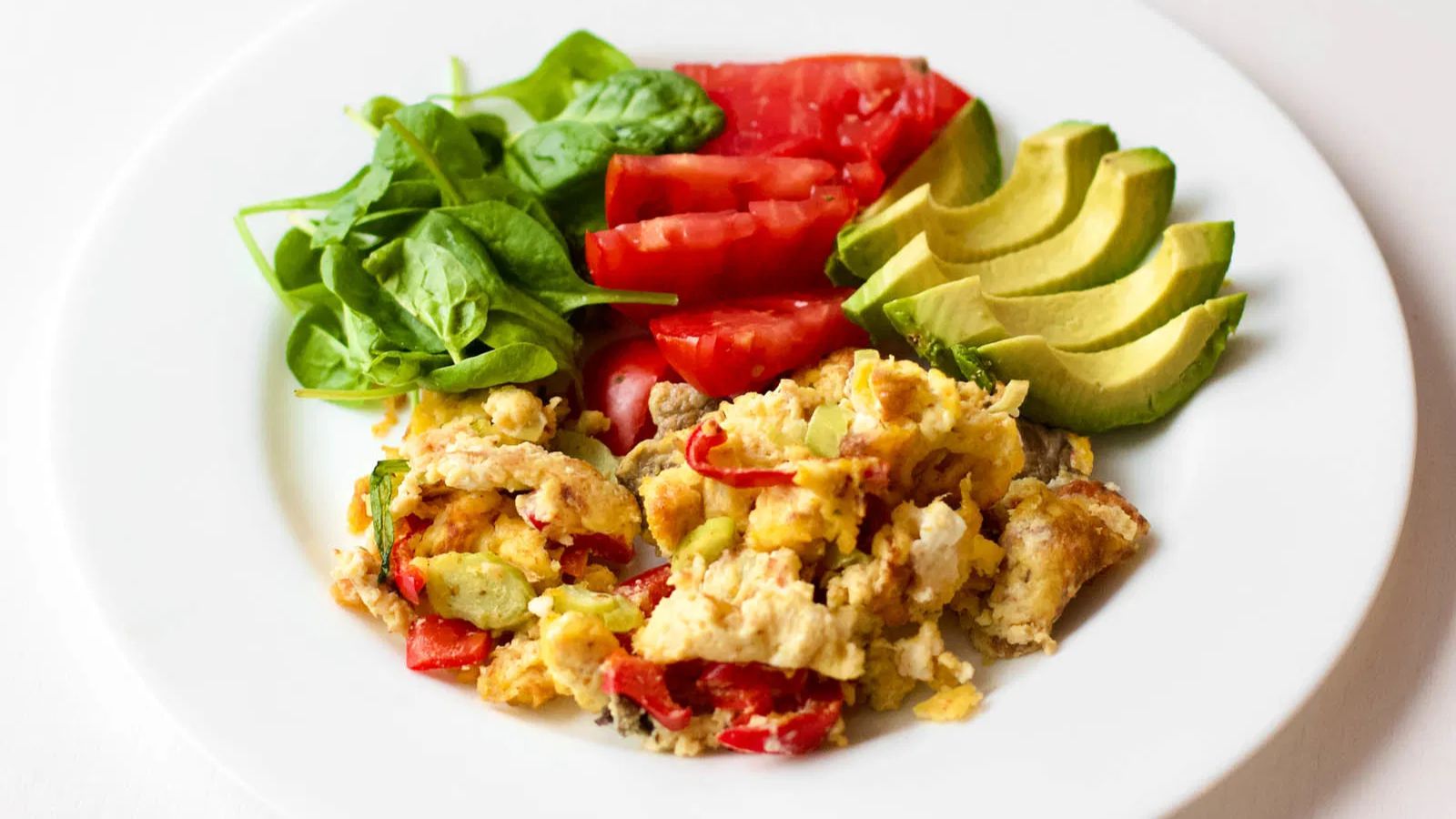 Colorful scrambled eggs on a plate.