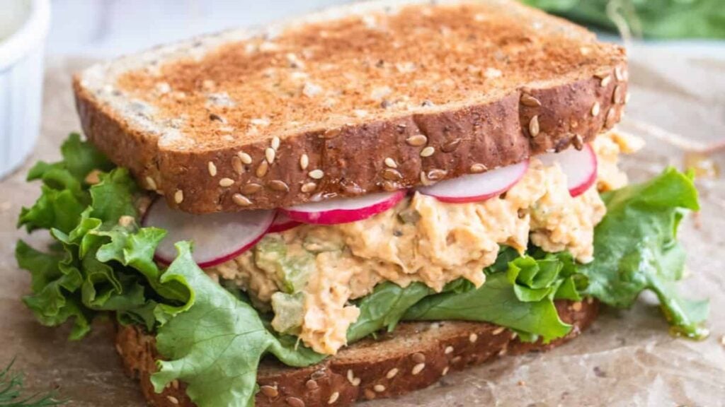 Chickpea sandwich on a wooden board.