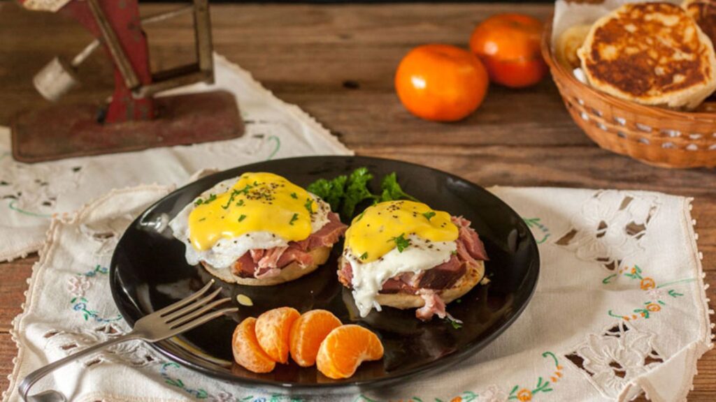 Eggs benedict on a black plate