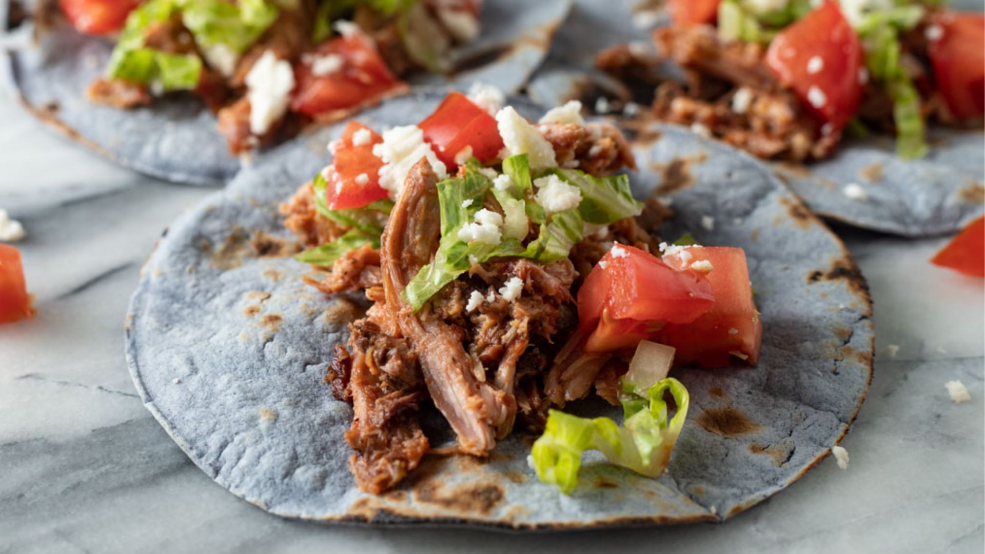 Close up of tacos on blue corn tortillas.