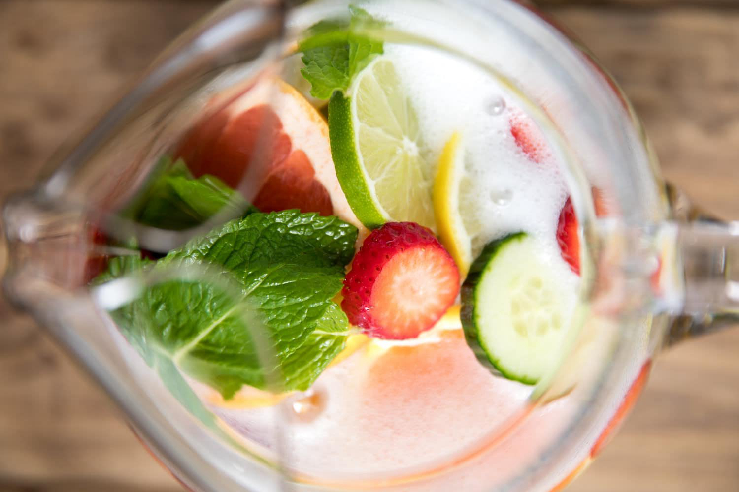 Fruit and mint in a pitcher overhead shot.