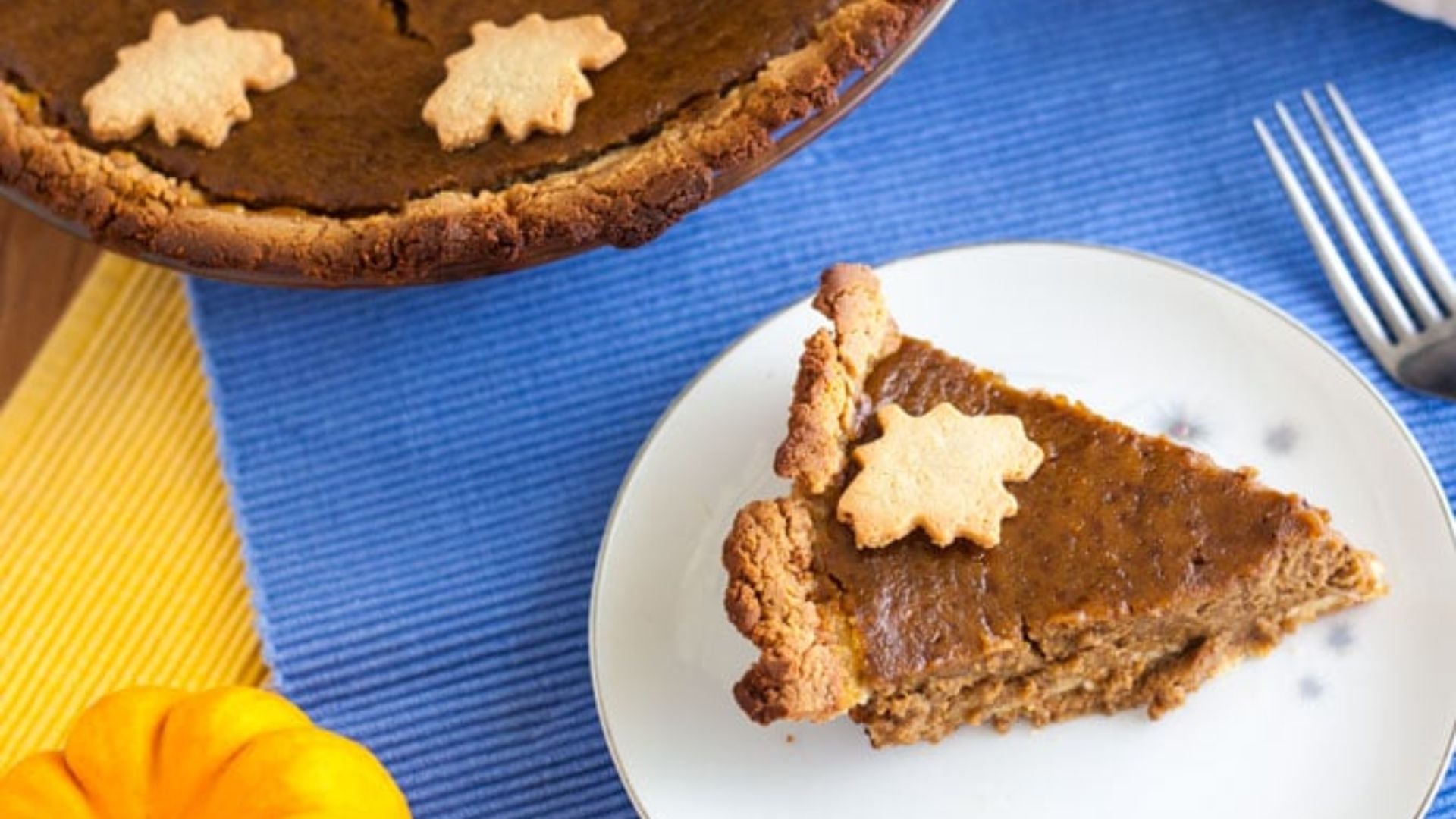 Dairy free pumpkin pie slice with dollop whipped cream on white plate