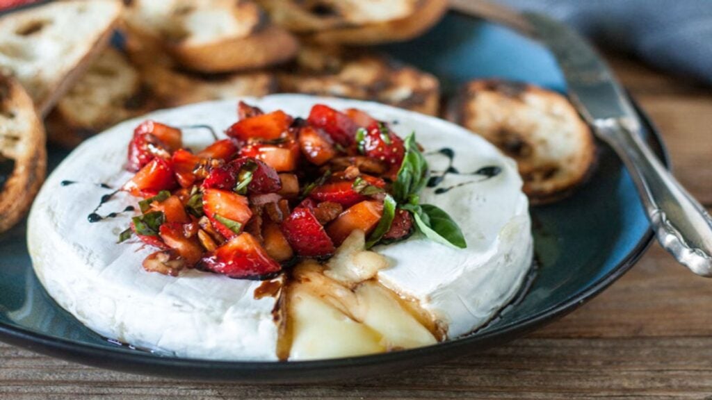 close up shot of grilled brie appetizer balsamic strawberries.