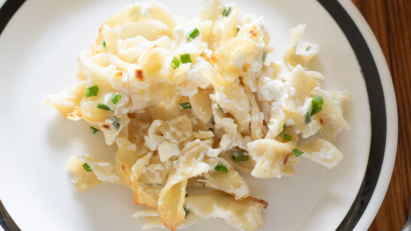 Close up of a serving of Casserole Marie Blanche on a white plate with black trim.