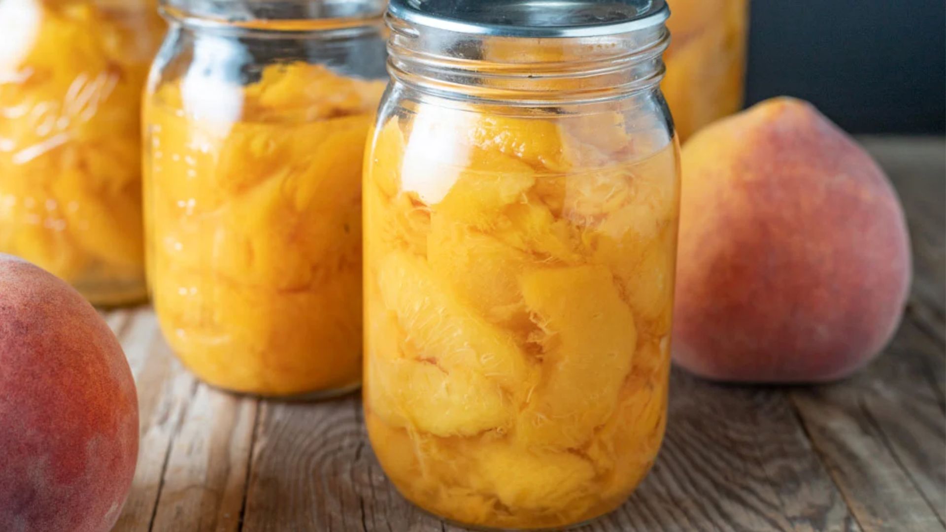 Canned peaches in jars close up shot.