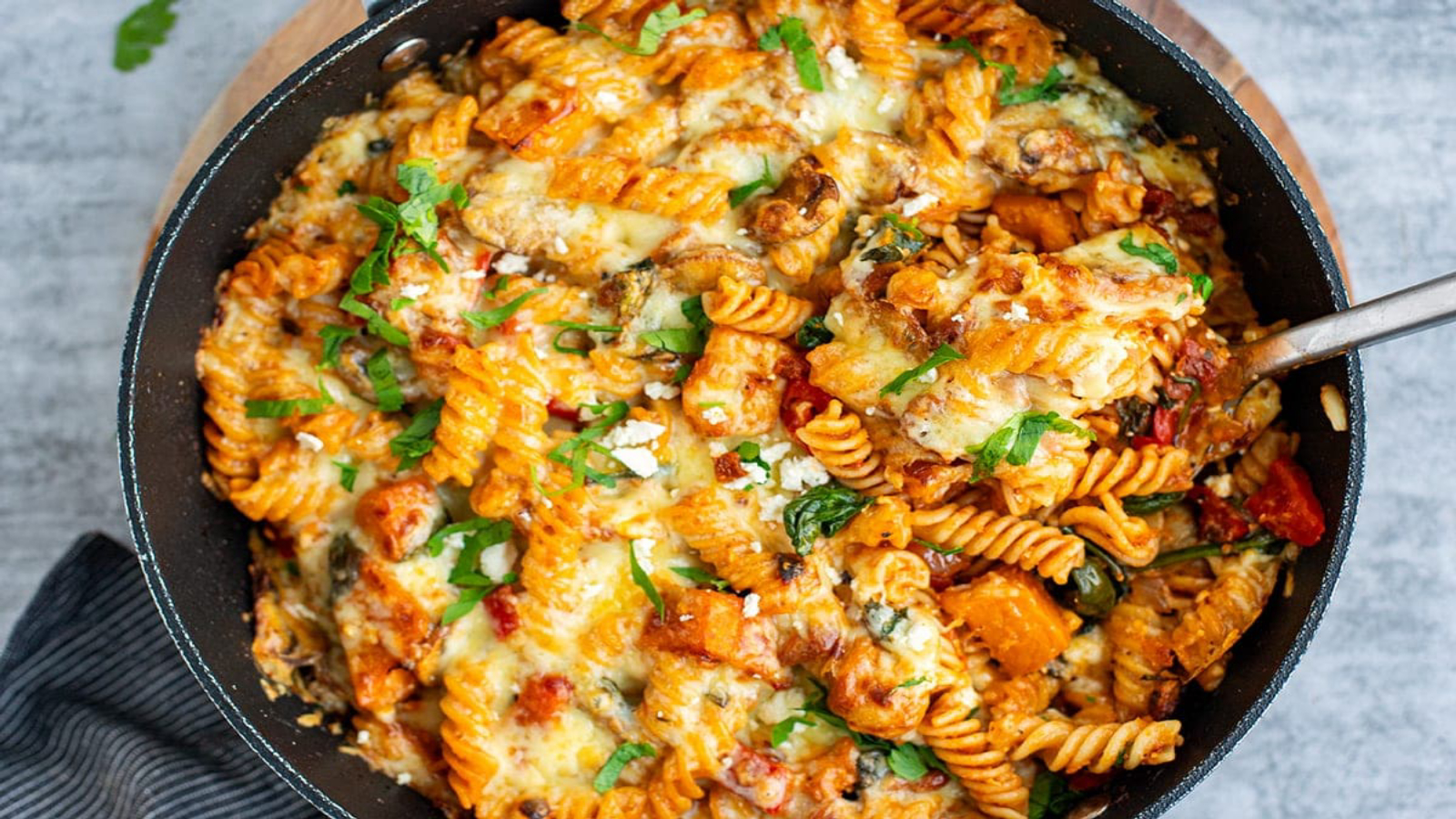 Vegetable pasta bake with melted cheese in a pan.