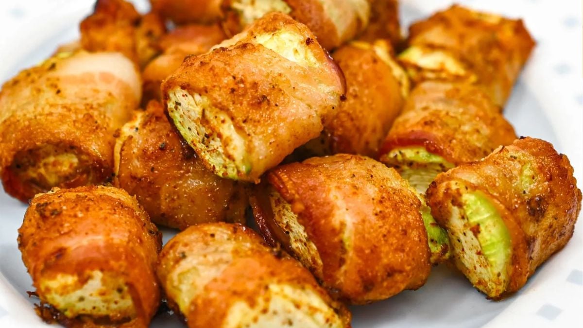 Crispy air fryer bacon-wrapped zucchini bites served on a plate.