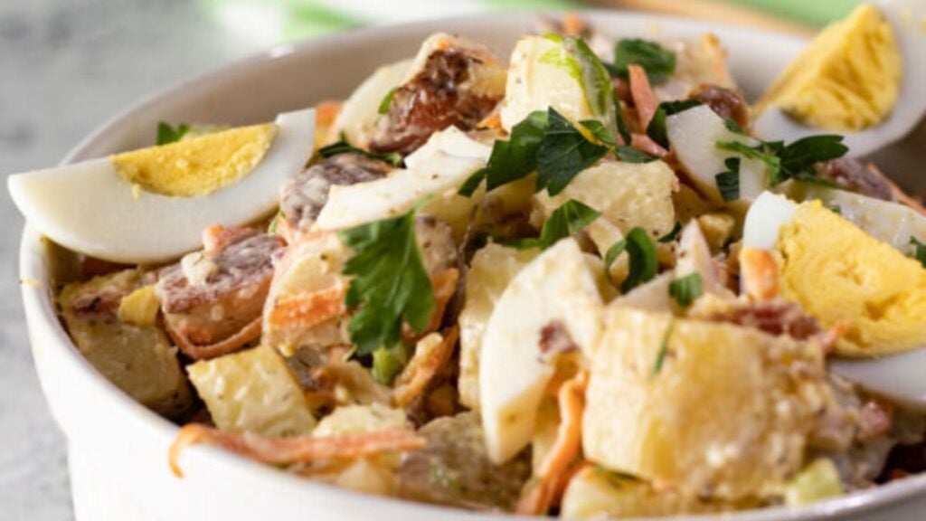 Bacon, potato and egg salad in a bowl.