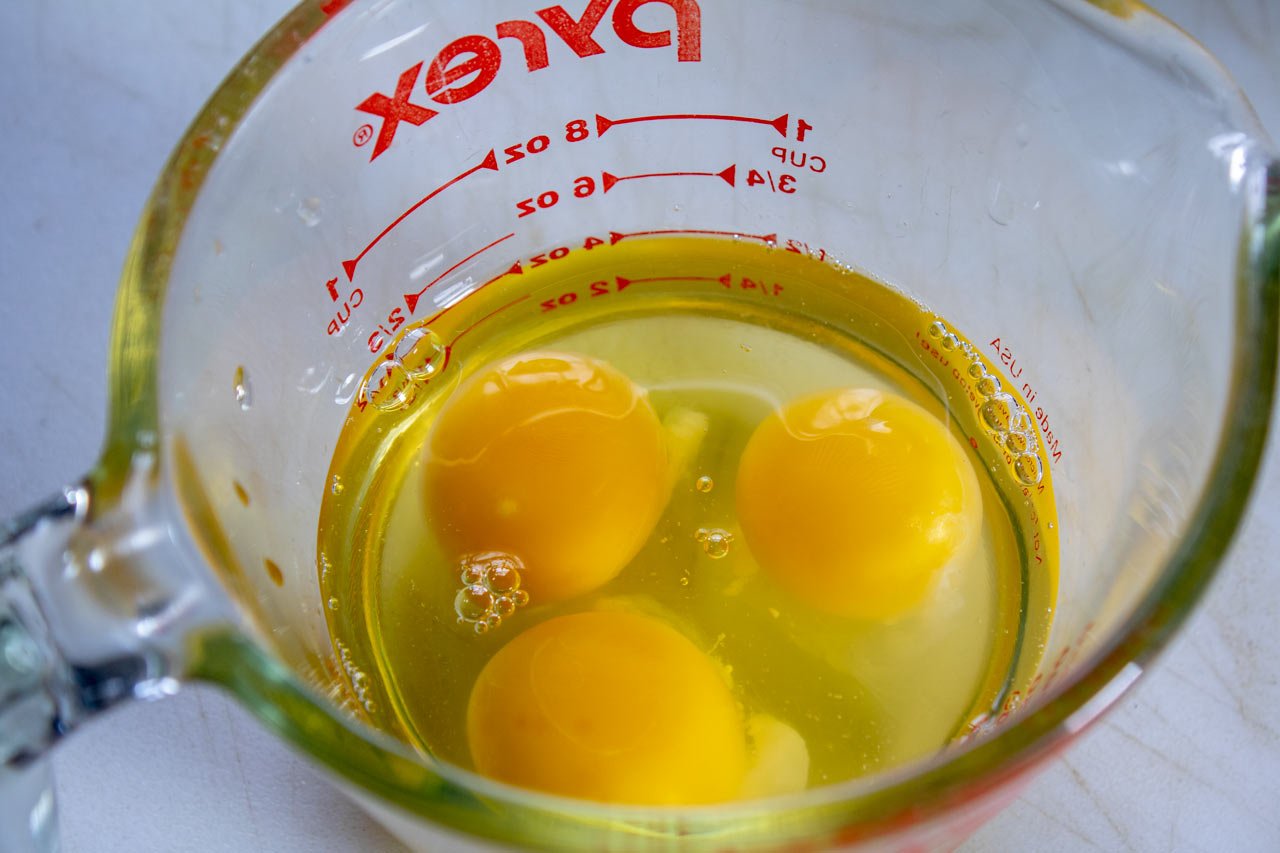 Eggs broken into a measuring cup.