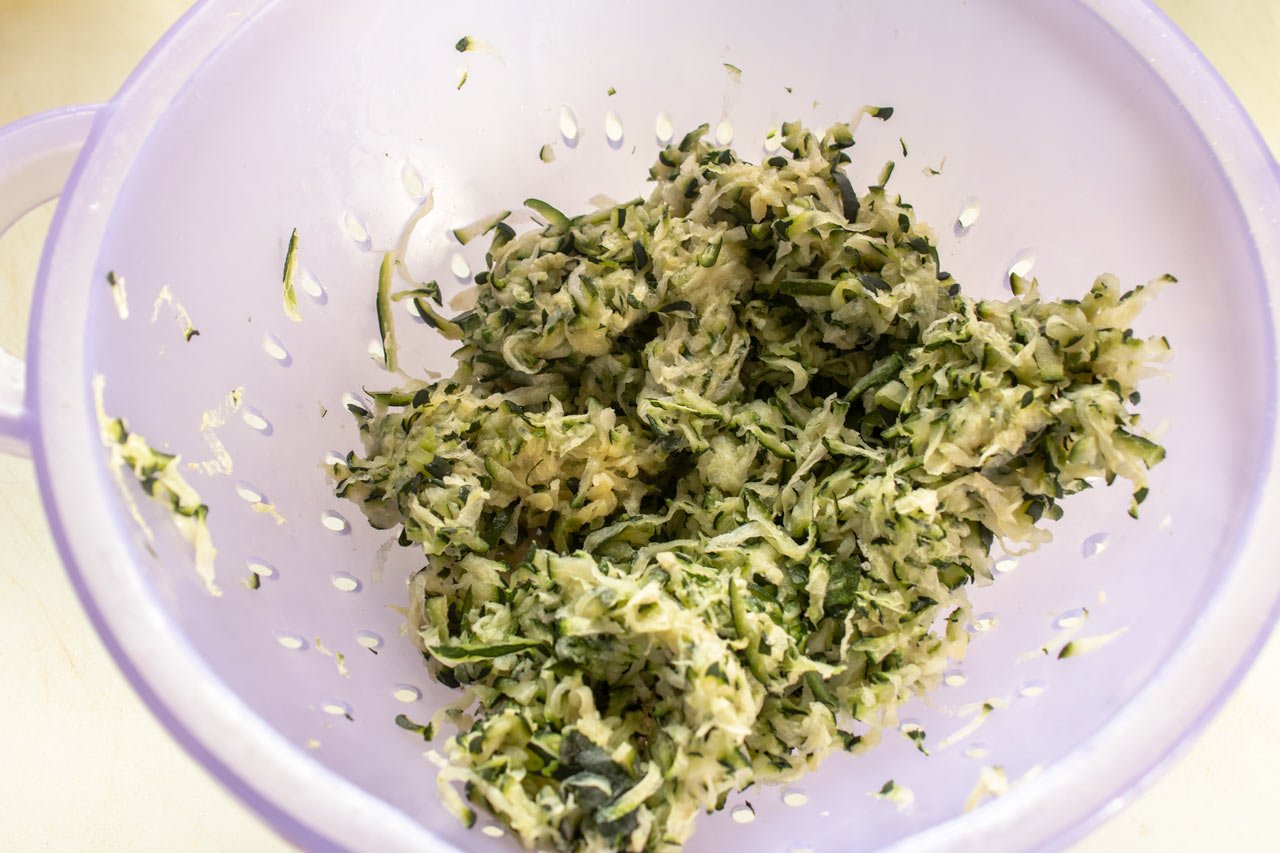 Grated zucchini in a colander.