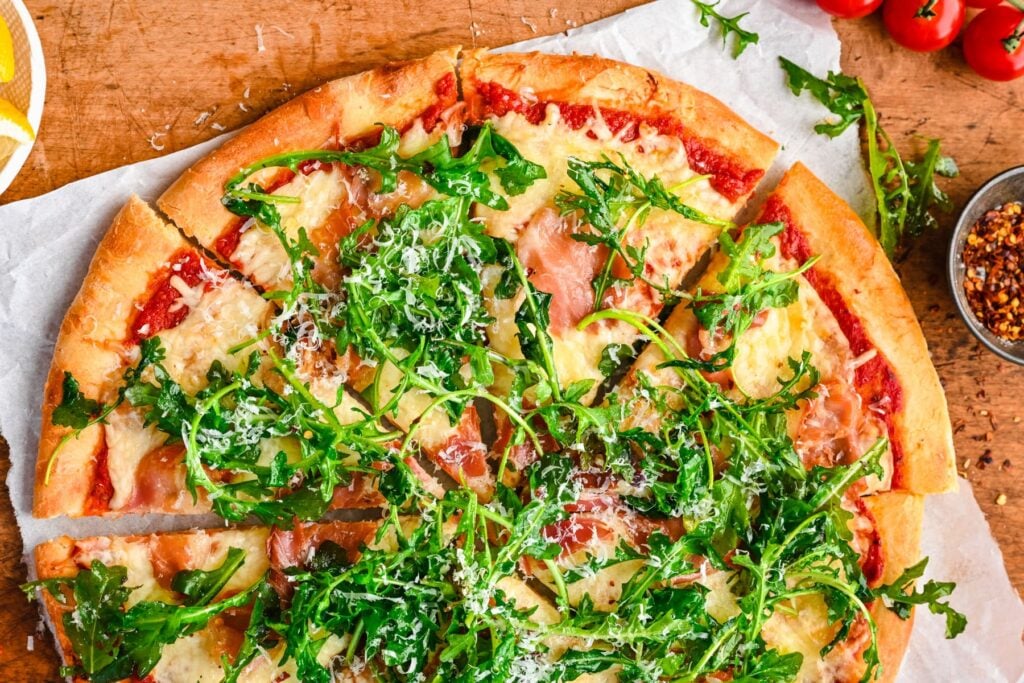 An overhead shot of sliced Arugula Prosciutto Pizza