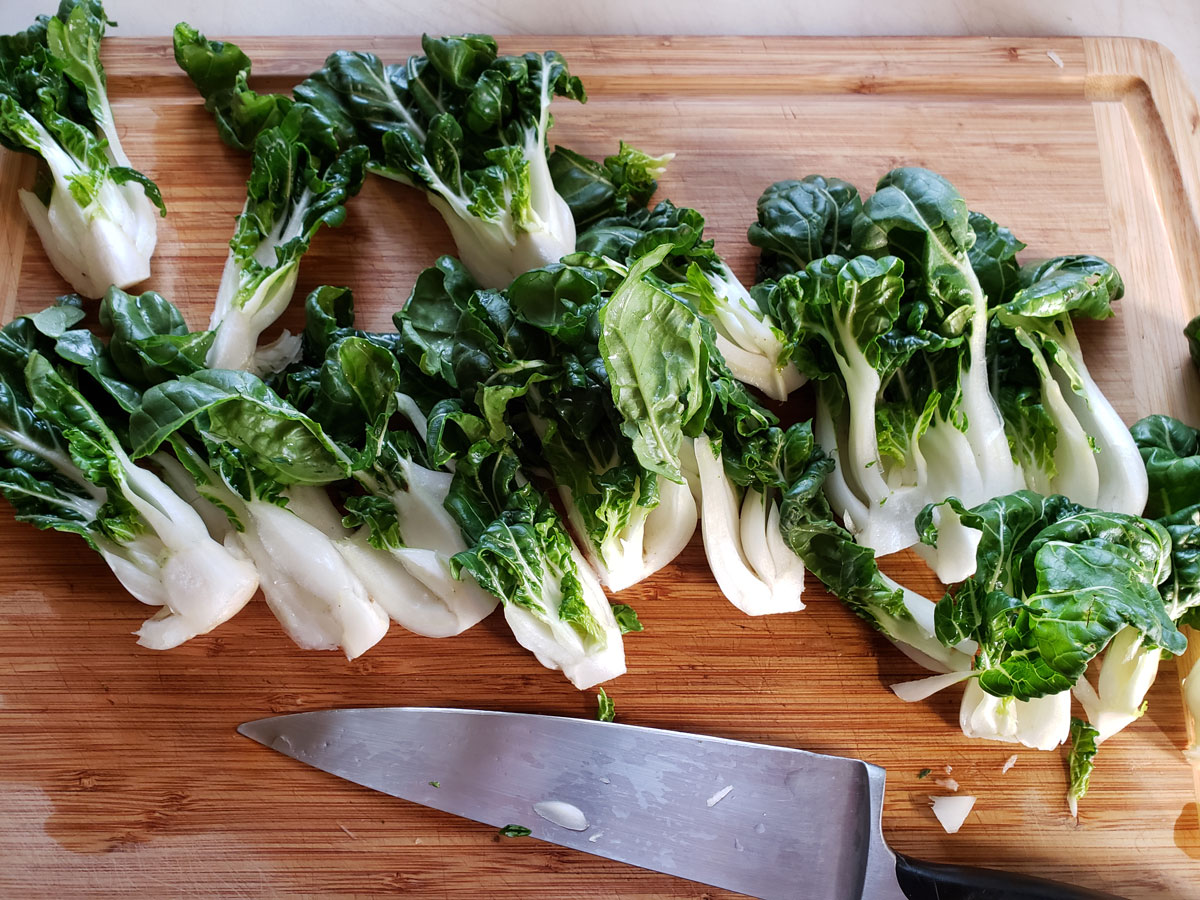 Bok choy chopped on a wooden cutting board.