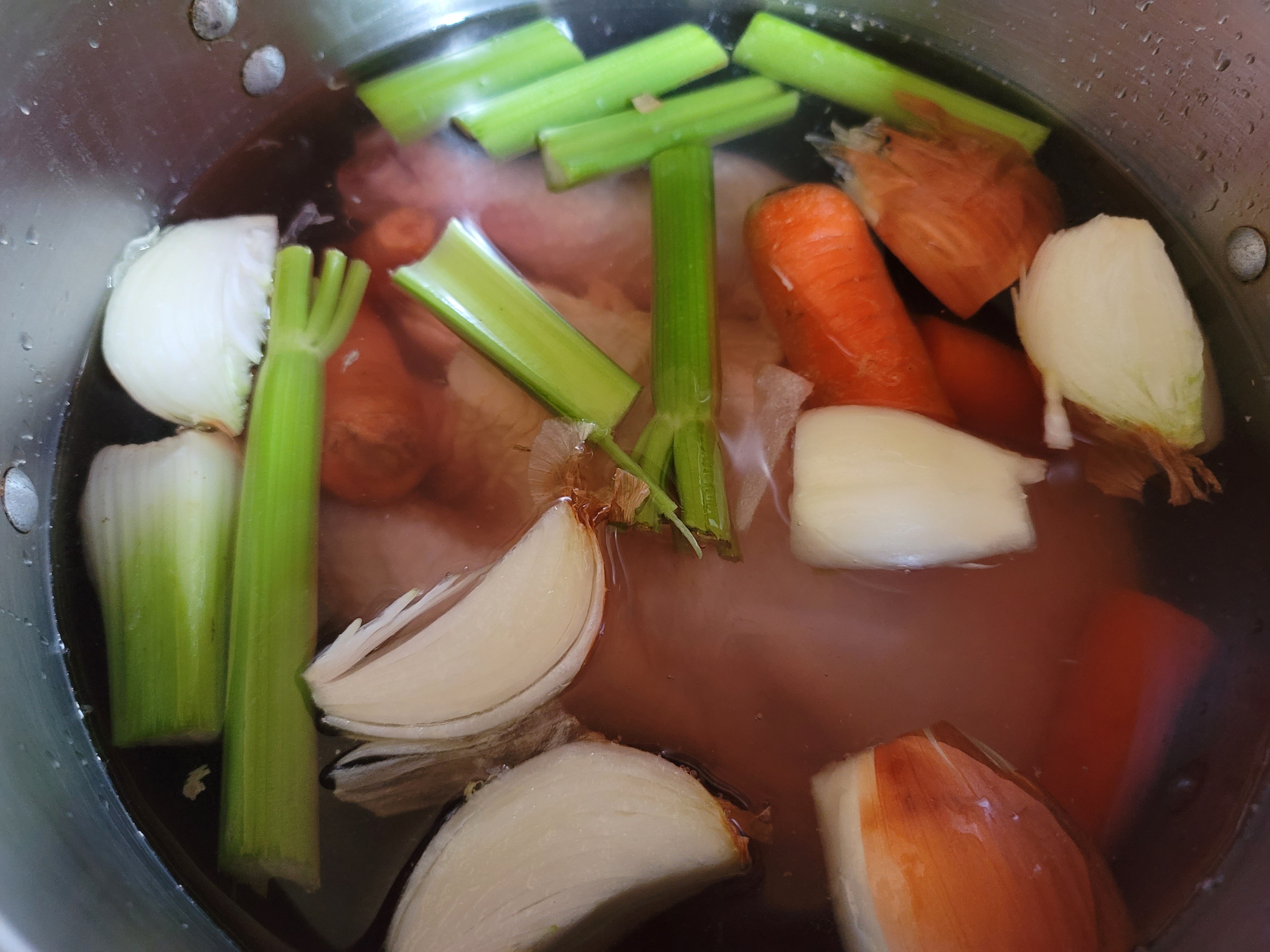Rough-chopped aromatics added to the chicken.