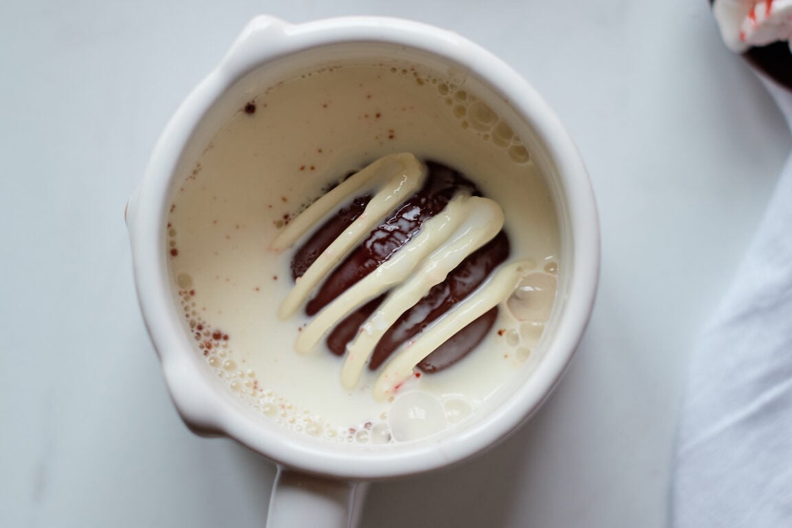 A mug with milk and Hot Chocolate Bomb inside.