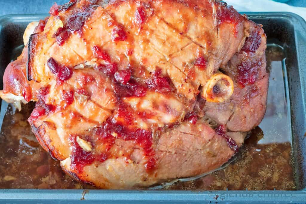 Baked Ham with Cranberry Glaze on a baking tray.